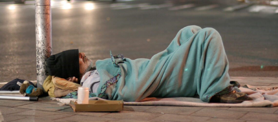 Homeless man sleeping in the street in UK being photographed in public