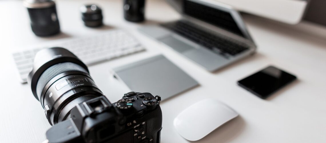 White Desktop Of A Successful Designer With A Laptop With A Mouse With A Modern Professional Camera With A Keyboard With A Laptop With A Graphic Tablet With A Computer. Stylish Workplace.